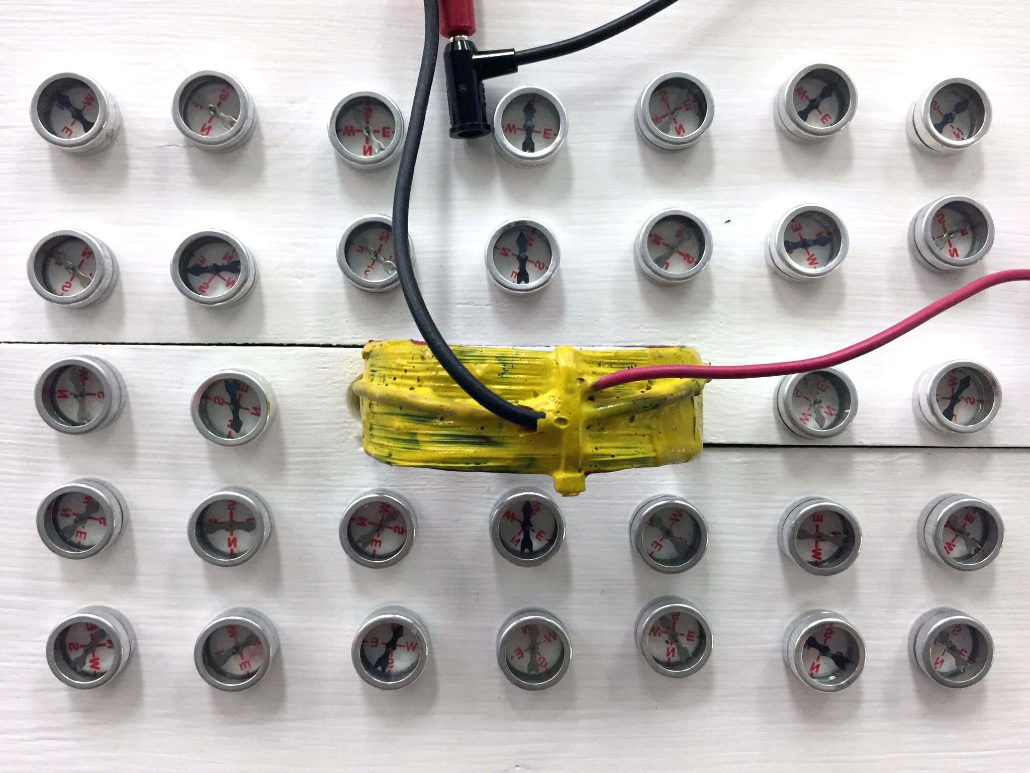 a bar magnet is positioned near a coil of wire